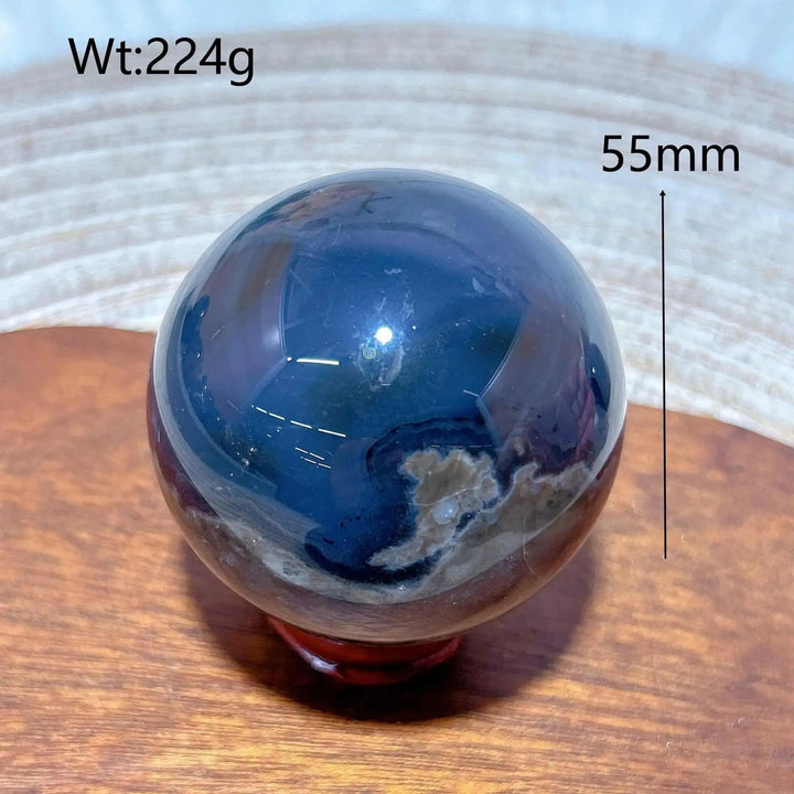 Volcanic Agate Sphere, a 55mm, 224g UV reactive crystal ball, showcasing its dark, earthy tones and unique geological fingerprint.