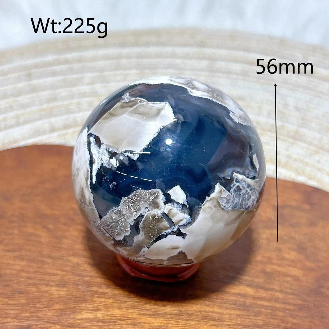 Volcanic Agate Sphere, 56mm, 225g. Earthy, banded crystal ball with dark blue and white patterns, UV reactive.