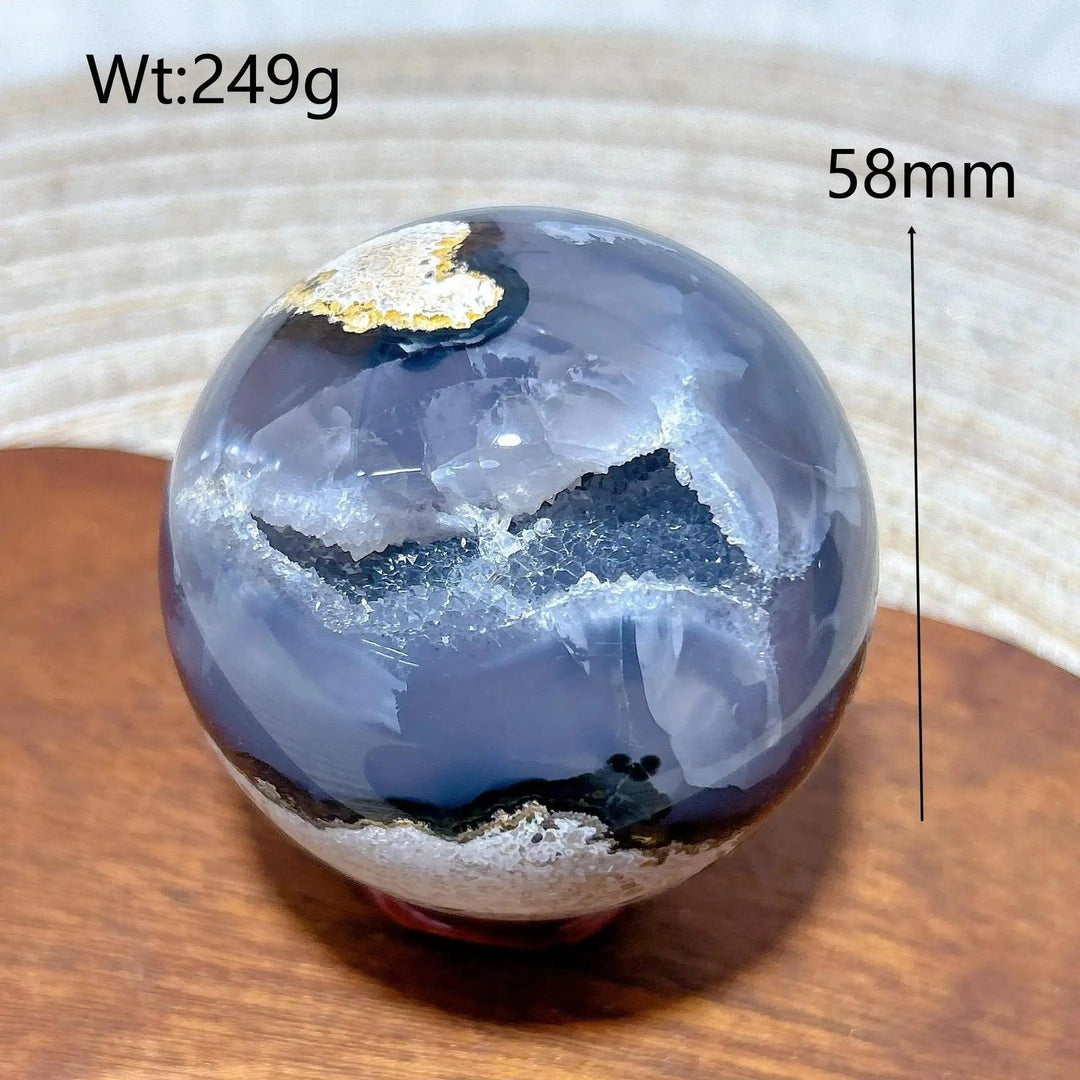 Volcanic Agate Sphere, a 58mm, 249g polished crystal ball with deep blue-grey bands and sparkling white druzy geodes.