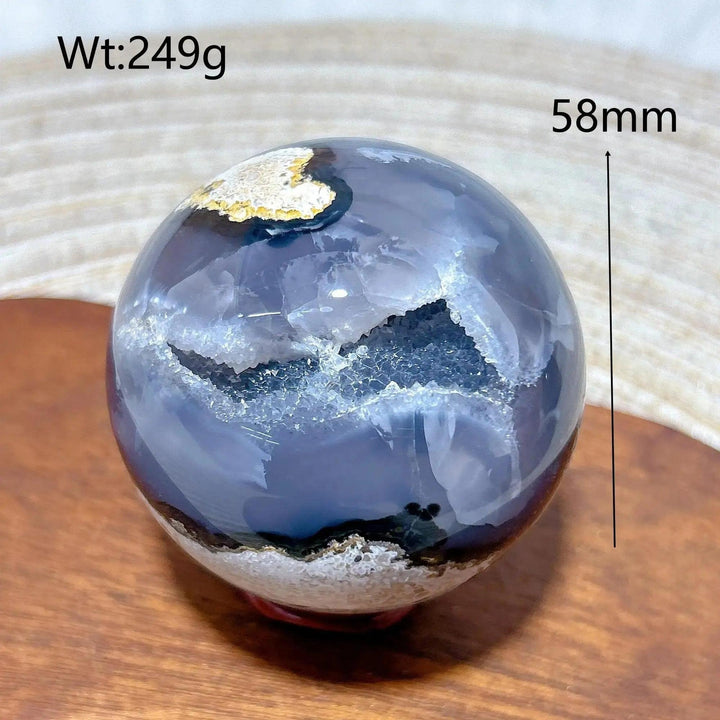 Volcanic Agate Sphere, a 58mm, 249g polished crystal ball with deep blue-grey bands and sparkling white druzy geodes.