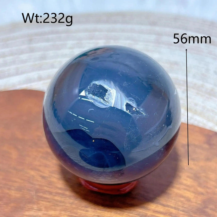 Volcanic Agate Sphere, a 232g, 56mm dark, polished crystal ball with a geode opening, grounding and transformative.