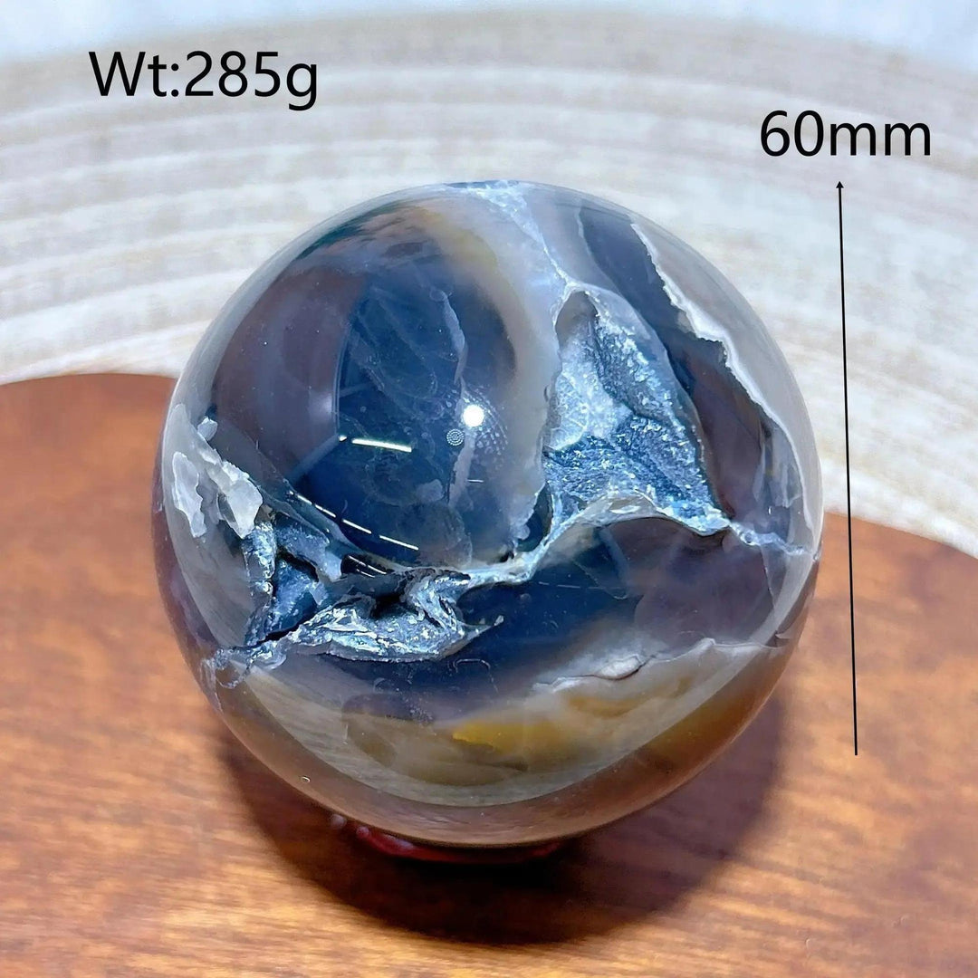 Volcanic Agate Sphere, a 60mm UV reactive crystal ball with earthy bands and hidden fluorescent colors.