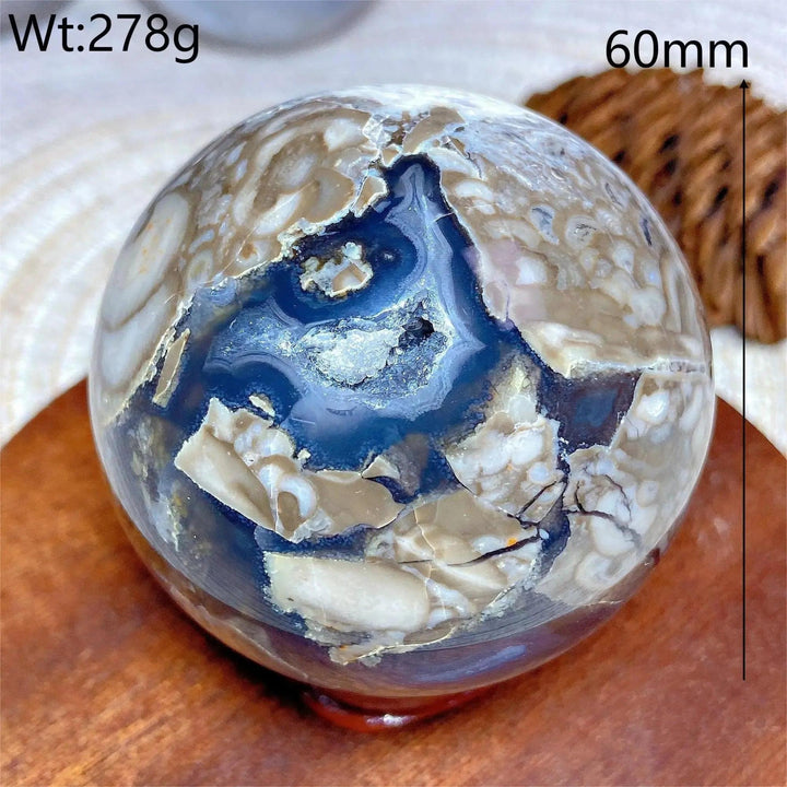 Volcanic Agate Sphere, a 60mm UV reactive crystal ball with earthy bands and a deep blue geode center.