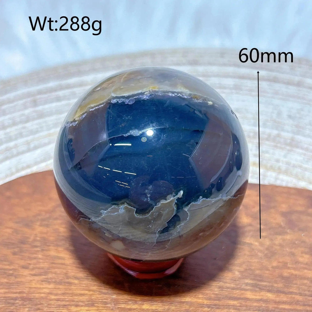 Volcanic Agate Sphere, 60mm, 288g. Hand-polished, UV reactive crystal ball with earthy and dark blue banding.