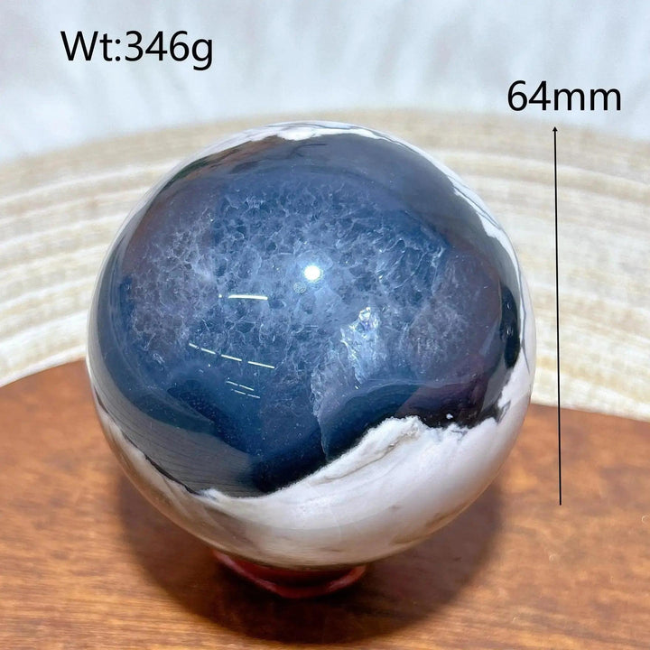 Volcanic Agate Sphere, a 346g, 64mm polished crystal ball with deep blue and white banding, UV reactive.