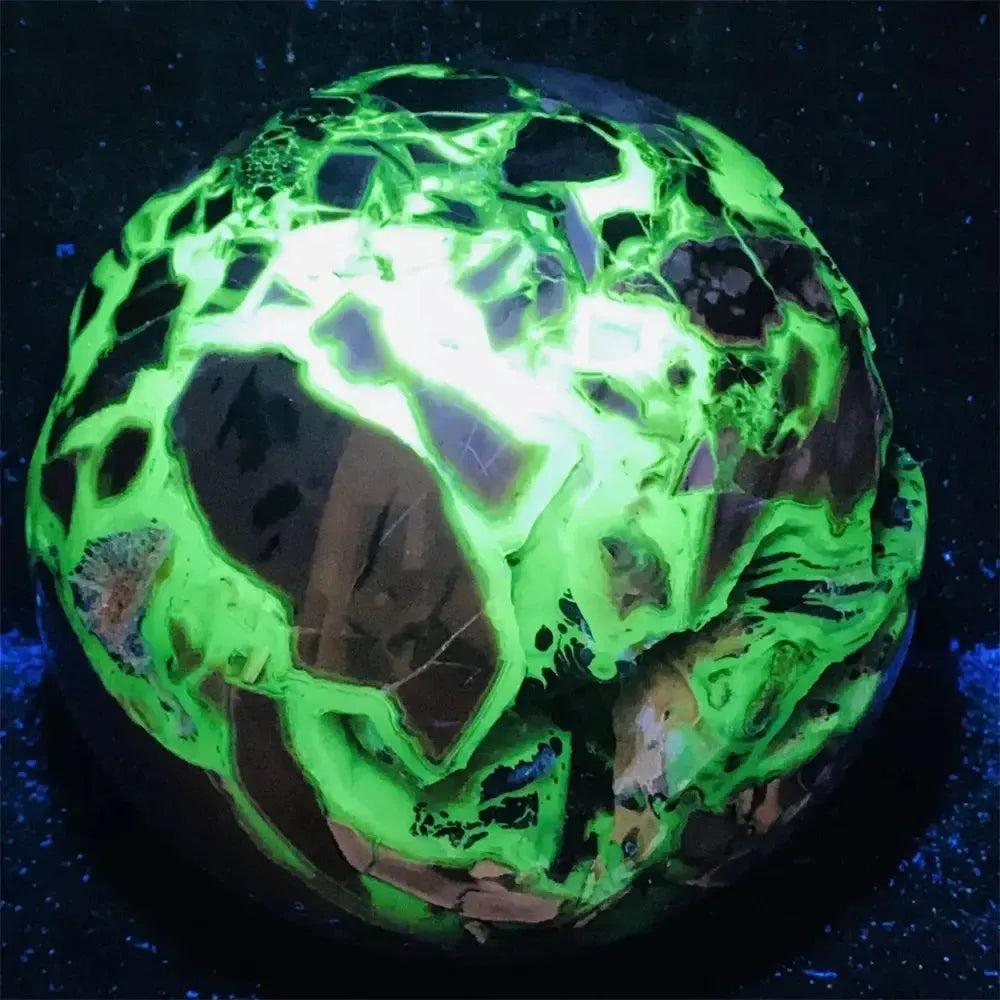 UV Reactive Volcanic Rock Agate Sphere glowing brilliant neon green under blacklight, revealing hidden depths.