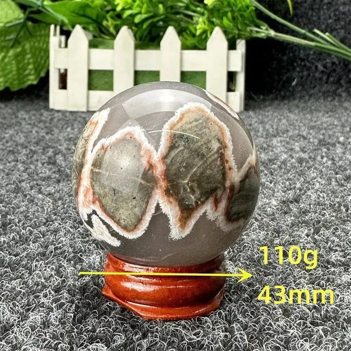 Volcano Agate sphere from Crystal Destiny, featuring fiery earth tones, intricate banding, and a polished finish.