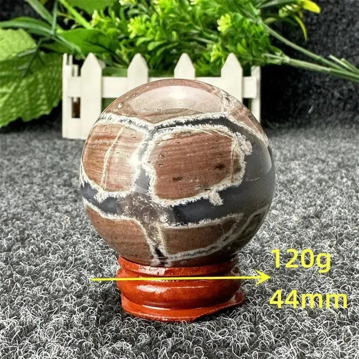 Volcano Agate sphere by Crystal Destiny, 120g, 44mm, with fiery earth tones and intricate banding on a wood stand.