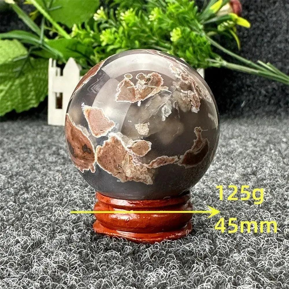 Volcano Agate sphere by Crystal Destiny, 125g, 45mm, with fiery earth tones and intricate banding on a wood stand.