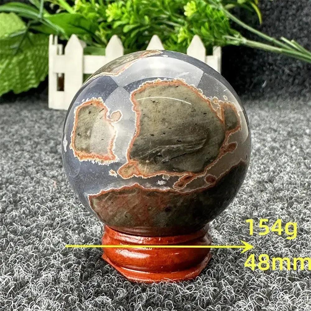 Polished Volcano Agate sphere from Crystal Destiny, displaying fiery earth tones, intricate banding, and grounding energy.