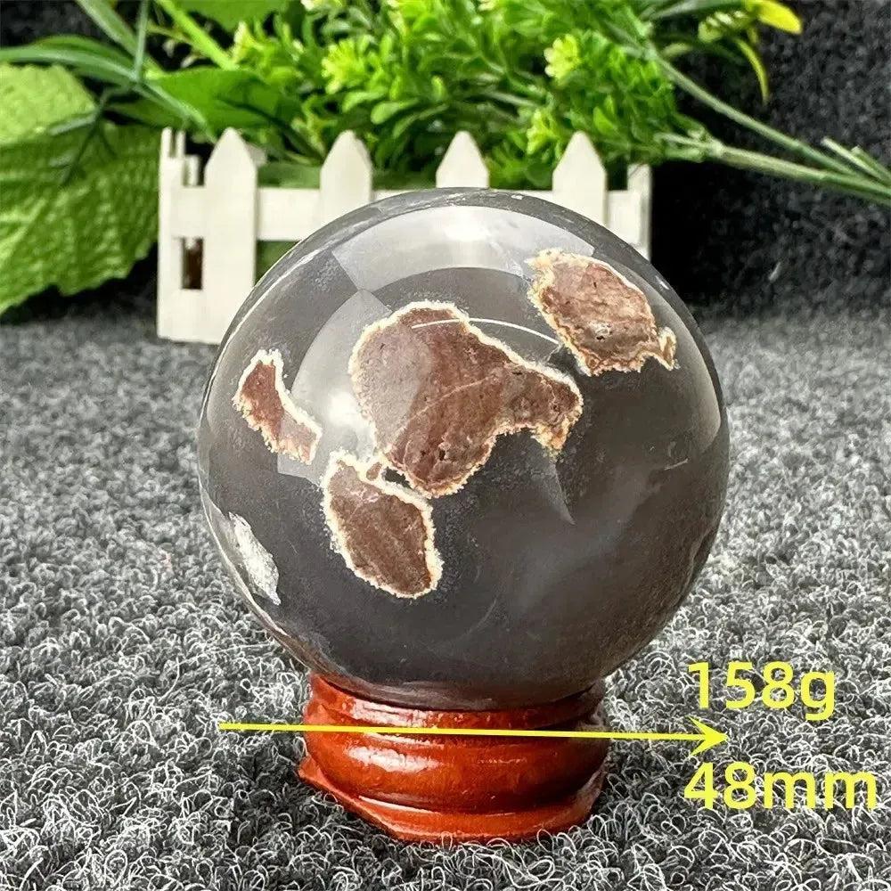Crystal Destiny Volcano Agate sphere, 158g, 48mm, with fiery earth tones and grounding energy on a wooden stand.