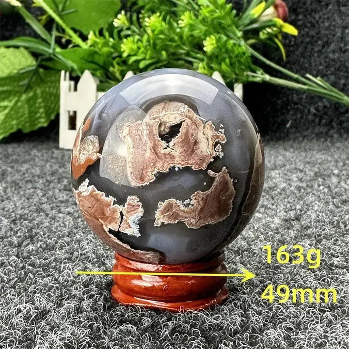 Volcano Agate sphere, 163g, 49mm, with fiery earth tones and dramatic patterns on a wooden stand from Crystal Destiny.