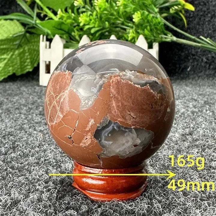 Volcano Agate sphere from Crystal Destiny, 165g, 49mm, with fiery earth tones and intricate banding on a wooden stand.