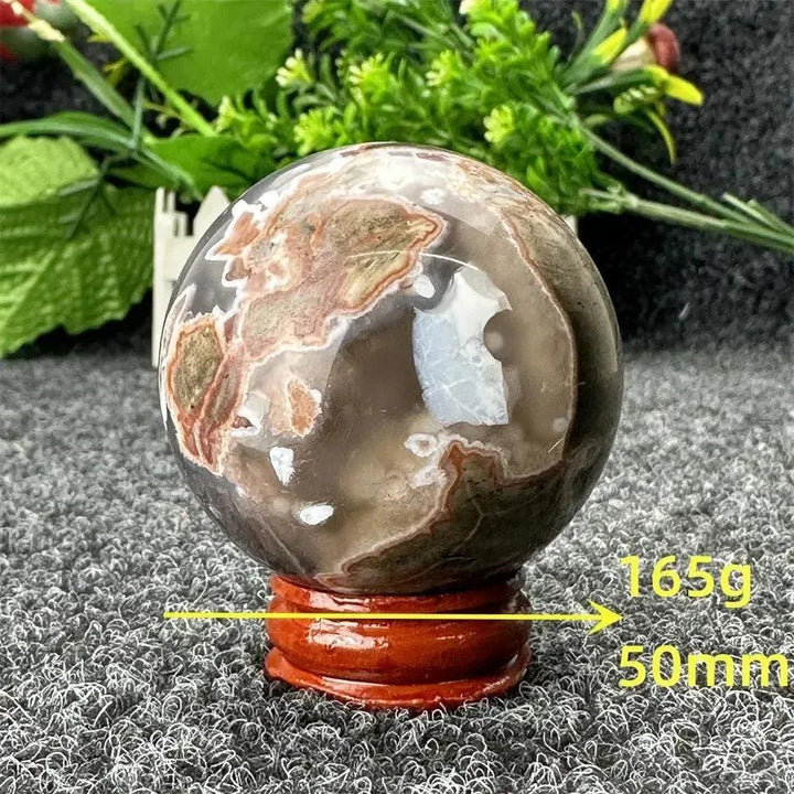 Volcano Agate sphere by Crystal Destiny, 50mm, 165g, with fiery earth tones and dramatic patterns on a wooden stand.