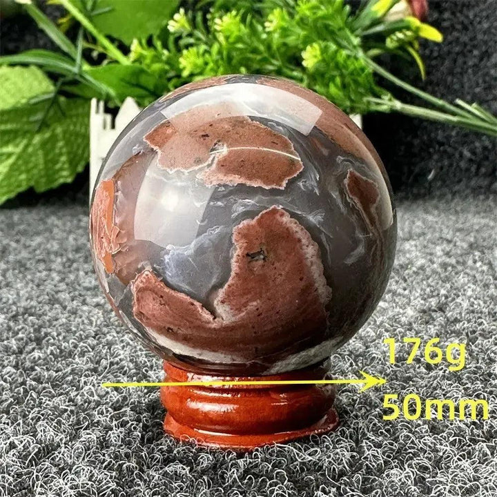 Volcano Agate sphere by Crystal Destiny, 50mm, 176g, with fiery red, brown, and gray patterns on a wood stand.