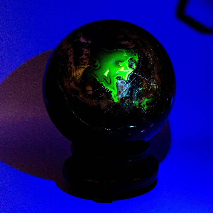 HUGE 186mm Volcano Agate Sphere, UV reactive, glowing vibrant green against dark volcanic patterns.
