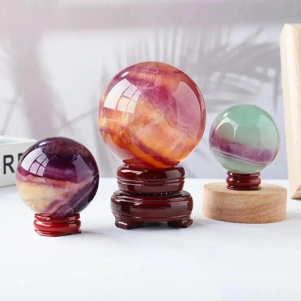 Three Watermelon Fluorite Crystal Spheres in varying sizes, showcasing vibrant green, pink, purple, and orange hues.