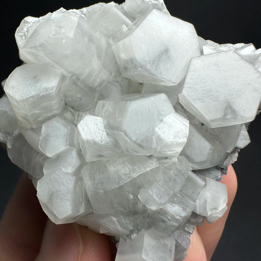 Raw white calcite crystal cluster healing stone with shimmering hexagonal mineral specimens.