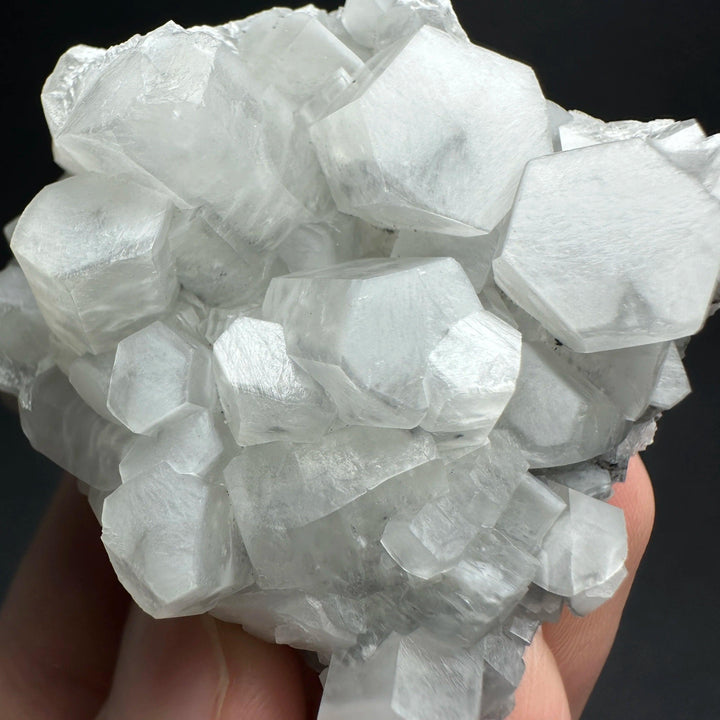 Raw white calcite crystal cluster healing stone with shimmering hexagonal mineral specimens.