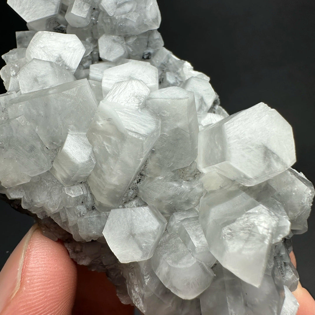Raw white calcite crystal cluster healing stone with shimmering hexagonal mineral structures.