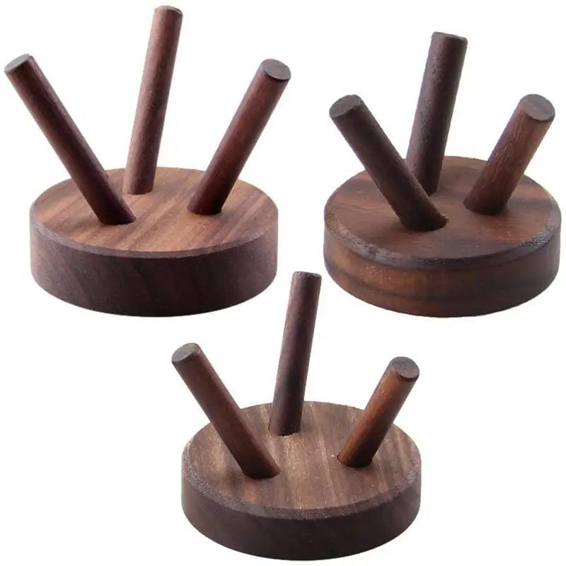 Three dark brown natural wood display stands with three angled pegs each, for crystals and minerals.