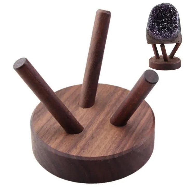 Dark brown wooden display stand with three angled pegs, shown holding a small amethyst geode.