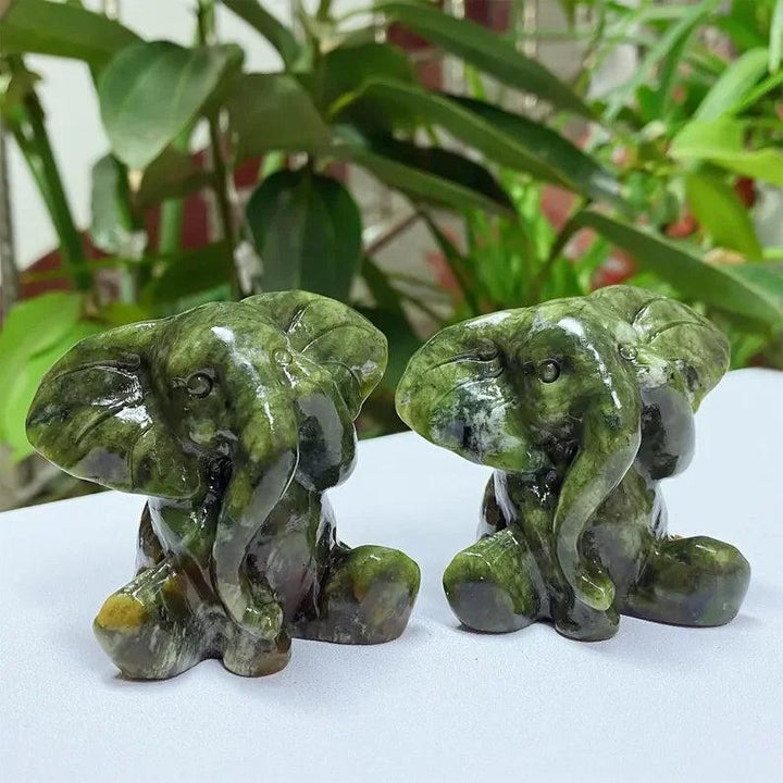 Hand-carved Xiuyan Jade elephant figurines in deep forest green, promoting grounding and stability for your home decor.