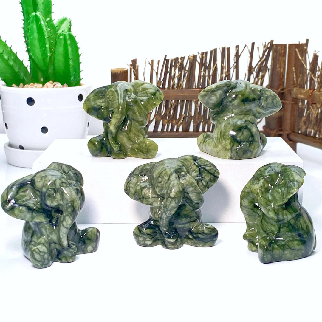 Five carved Xiuyan Jade elephant statues, deep waxy green with natural veining, symbolizing luck and wisdom.