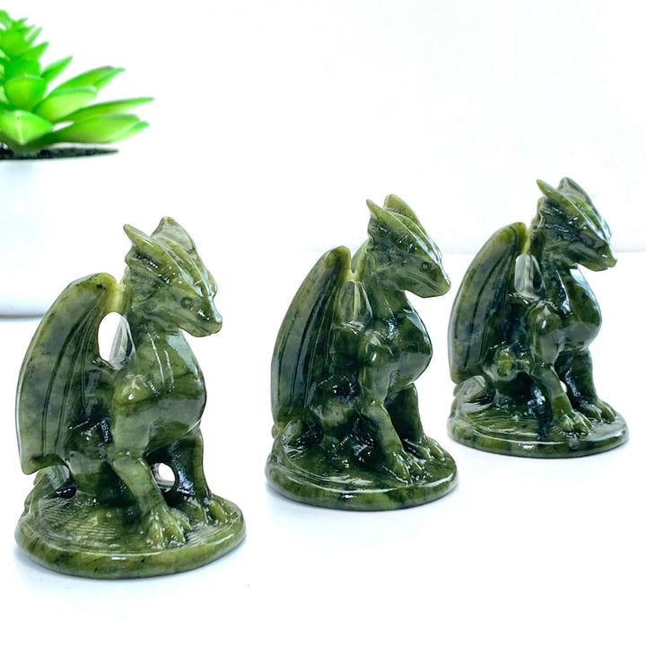 Three dark green Xiuyan Jade Pterosaur Dragon carvings, ideal for decor and promoting balance.