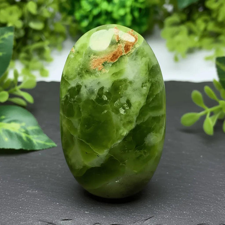 Polished green Xiuyu palmstone crystal with natural white and brown inclusions for healing and decor.