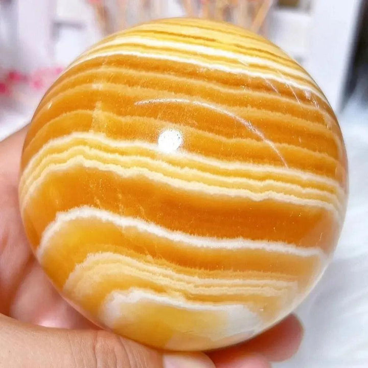 Polished Yellow Calcite Honey Calcite Sphere with warm honey-golden tones and natural banding, radiating uplifting energy.