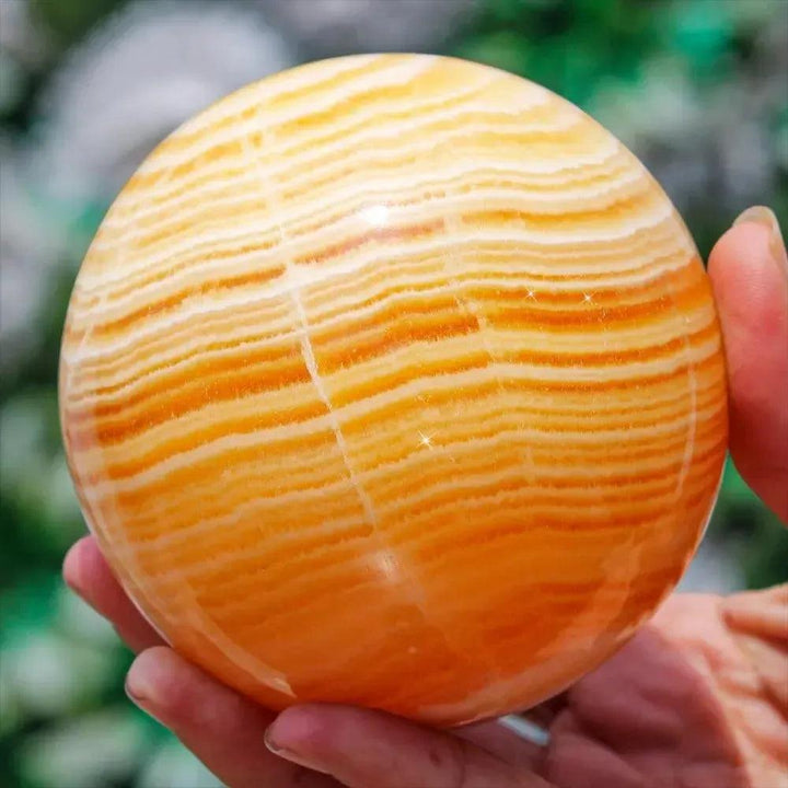 Polished Yellow Calcite Honey Calcite Sphere with warm honey-golden tones, natural banding, and striations.