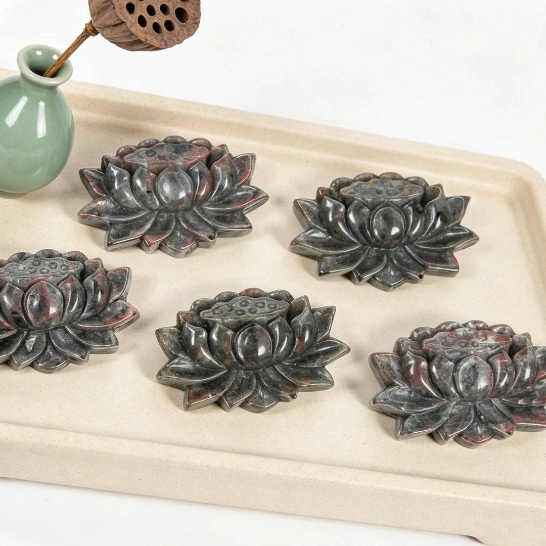 Five hand-carved Yooperlite lotus flower statues, detailed grey stone with red flecks, symbolizing peace and manifestation.