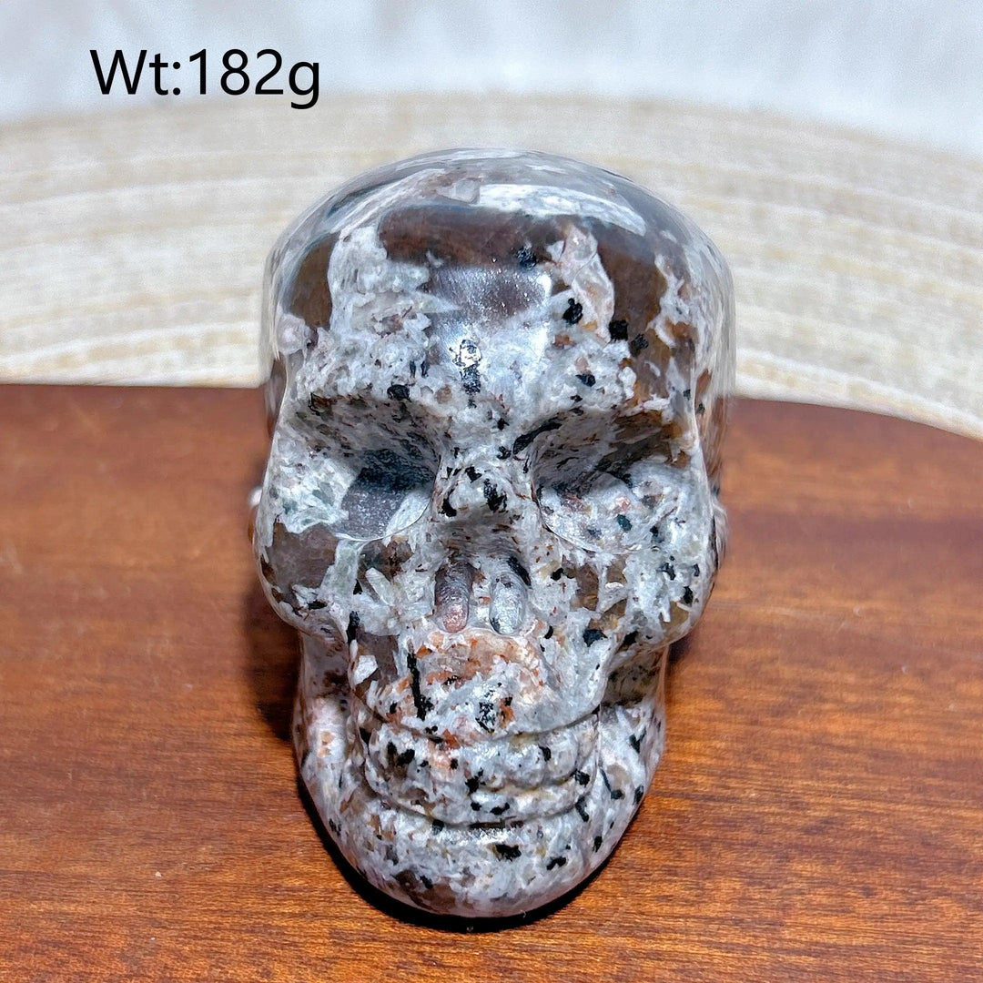 Yooperlite Crystal Carved Skull, a beautifully detailed grey stone with black and white specks, weighing 182g.