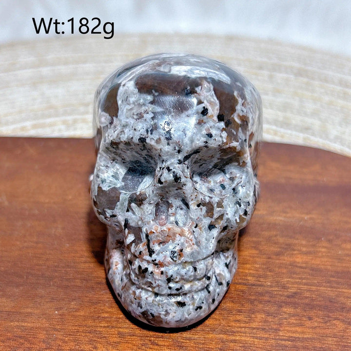 Yooperlite Crystal Carved Skull, a beautifully detailed grey stone with black and white specks, weighing 182g.