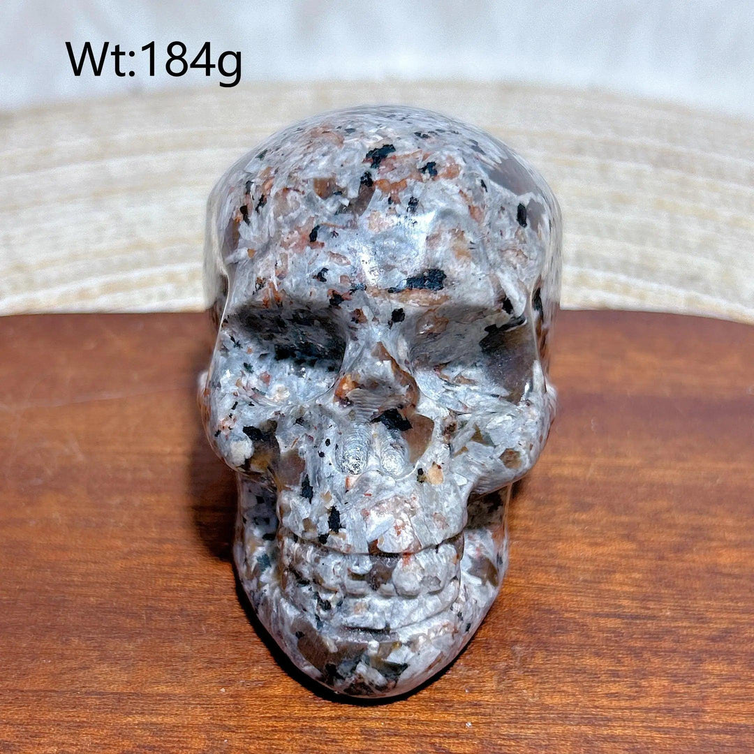 Yooperlite Crystal Carved Skull, a detailed grey stone with black and orange flecks, for protection and grounding.