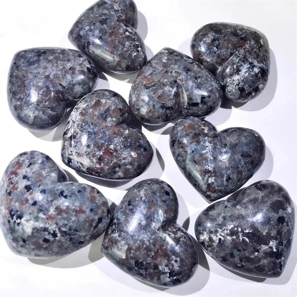 Yooperlite Crystal Heart Stone UV Reactive: Polished grey and white heart-shaped stones with reddish flecks.
