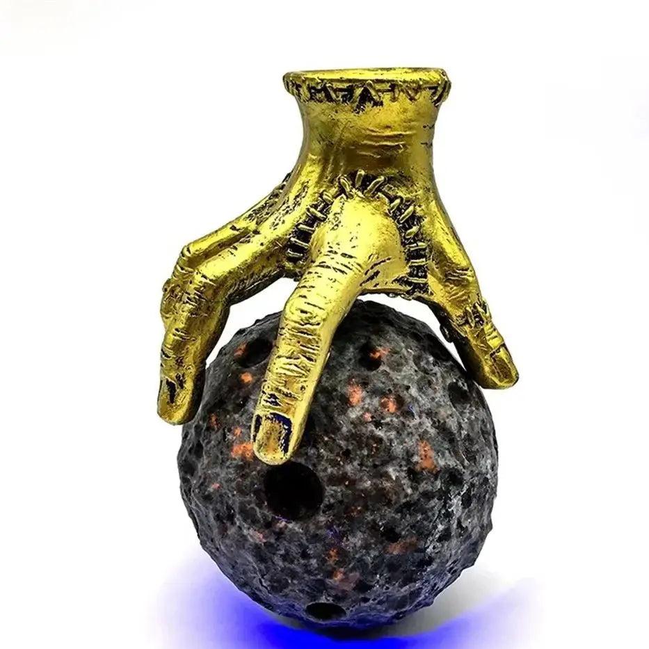 Yooperlite crystal moon sphere held by a gold hand stand, perfect for Reiki healing and spiritual witchcraft decor.