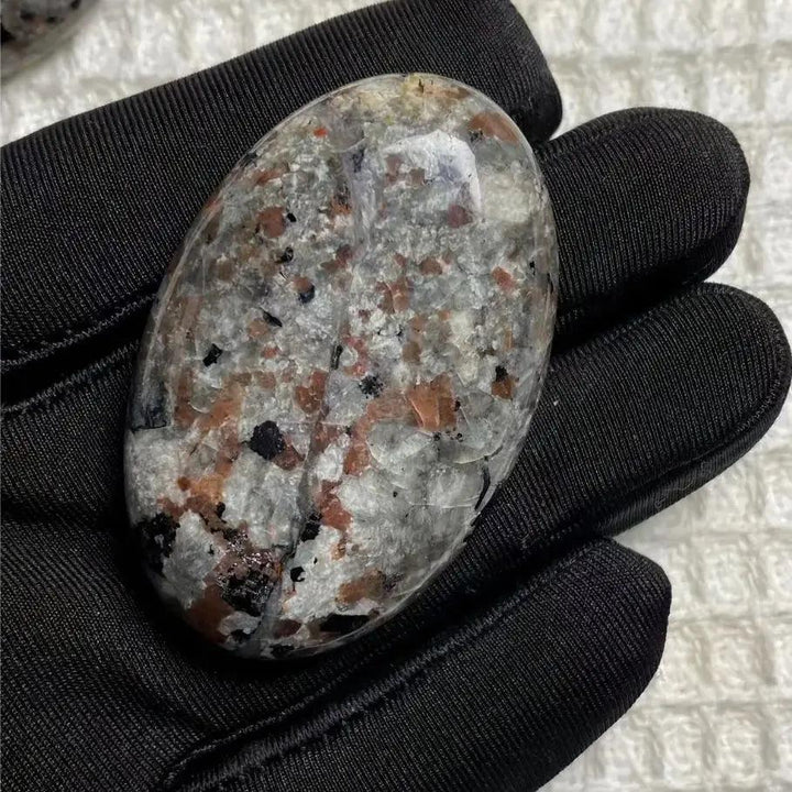 Yooperlite Crystal Palm Stone Flame UV Reactive Glow, a smooth grey stone with subtle flame-like patterns for grounding.