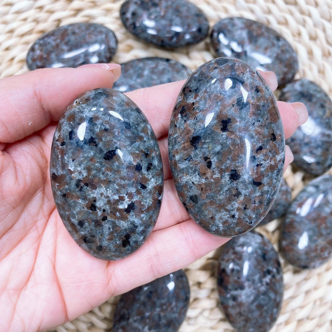 Polished Yooperlite palm stone with grey and brown speckled syenite, perfect for grounding and meditation.