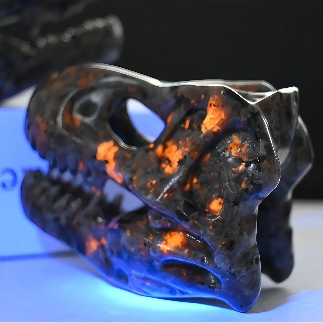 Yooperlite T-Rex skull carving, dark gray with vivid orange UV reactive glow, for protection and grounding.