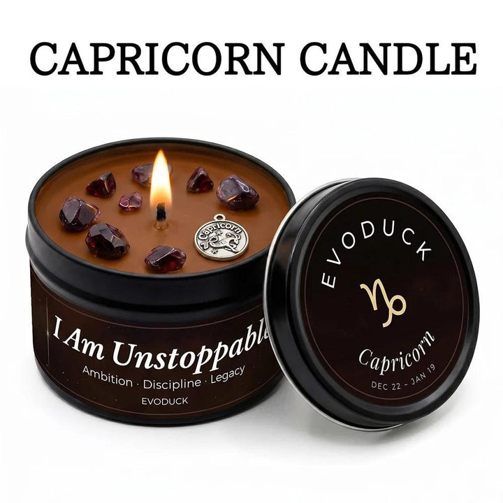 Capricorn White Tea & Sage tin candle with glowing flame, garnet crystals, and a silver zodiac charm.
